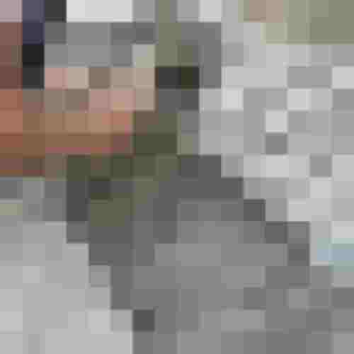 Handwerker setzt Natursteinpflaster in Splittbett und richtet Steine mit dem Hammer aus