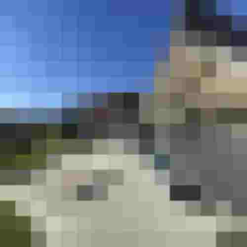 Moderne Naturstein-Terrasse mit großformatigen Platten und Stufen vor Einfamilienhaus mit Bergblick