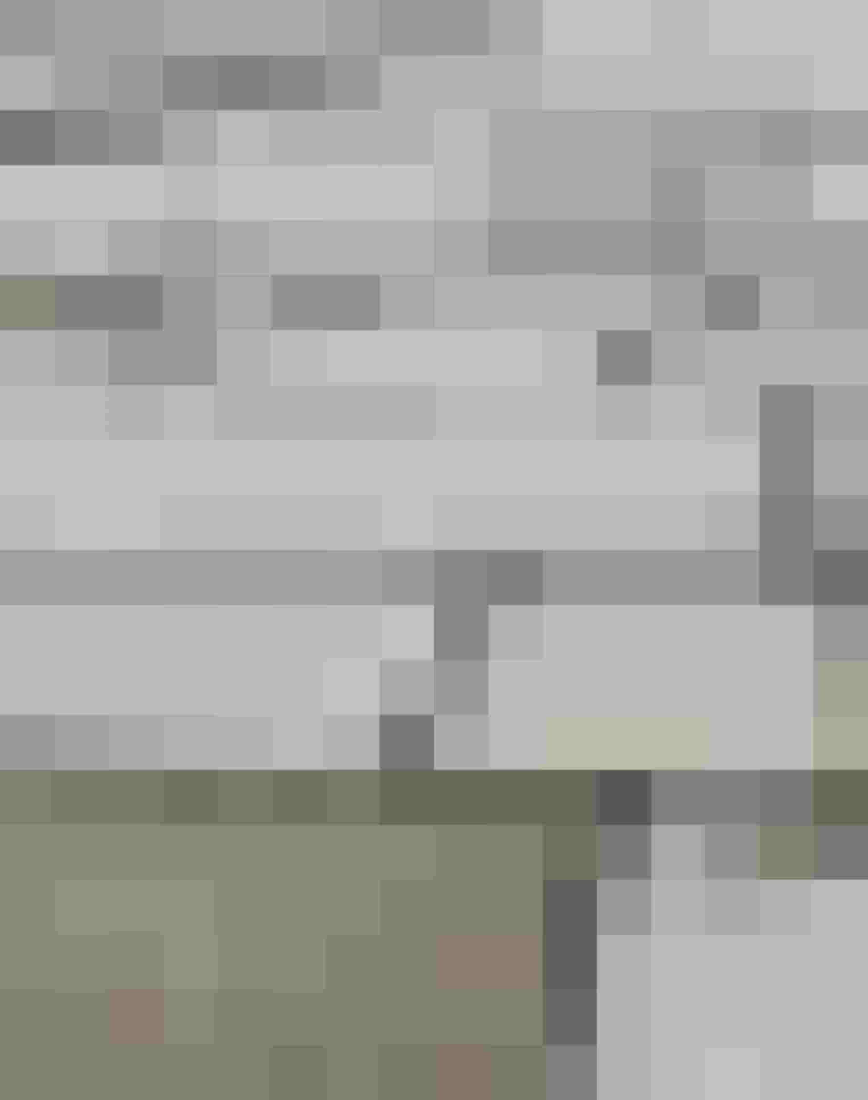 Nahaufnahme einer gepflasterten Fläche aus rechteckigen Betonsteinen in Grautönen mit Fugenbild